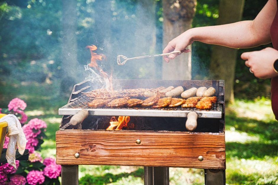 Glimmende cortenstalen barbecue in zonovergoten tuin. Glimmende cortenstalen barbecue in zonovergoten tuin.